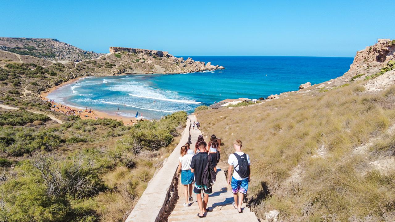 students walking toward a beach in Malta